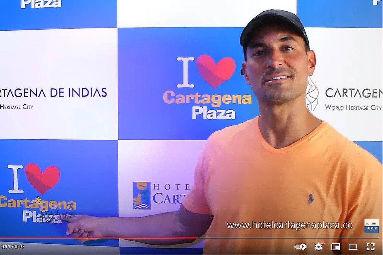 um homem está em frente a uma parede que diz i love cartagena plaza