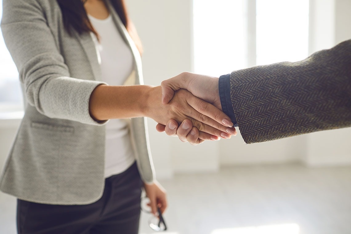 Two people closing a deal shaking hands