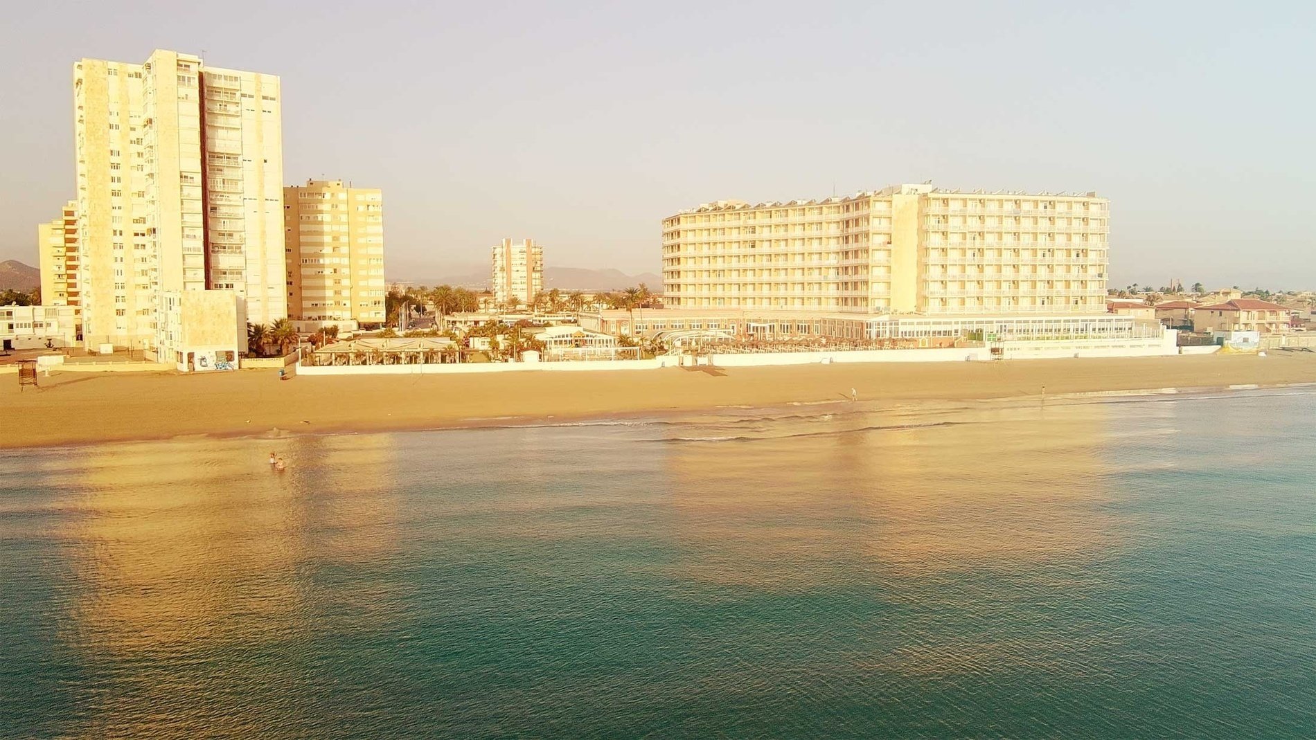 an aerial view of a beach with a building that says ' hotel ' on it