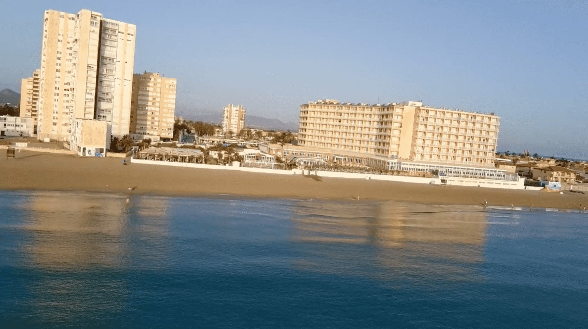 a beach with a large building in the background