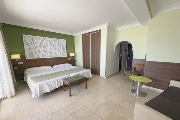 una habitación de hotel con dos camas , una mesa y una silla .