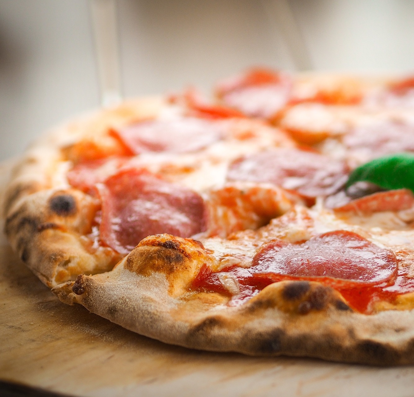 a pepperoni pizza is sitting on a wooden cutting board