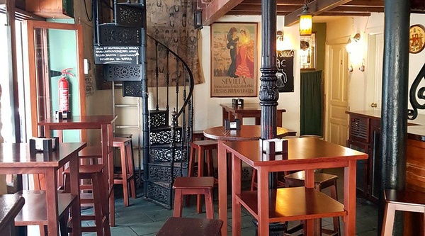 Una mano sirve aderezo cremoso sobre finas lonchas de carne en Epoca Suites: Casa del Gitano.
