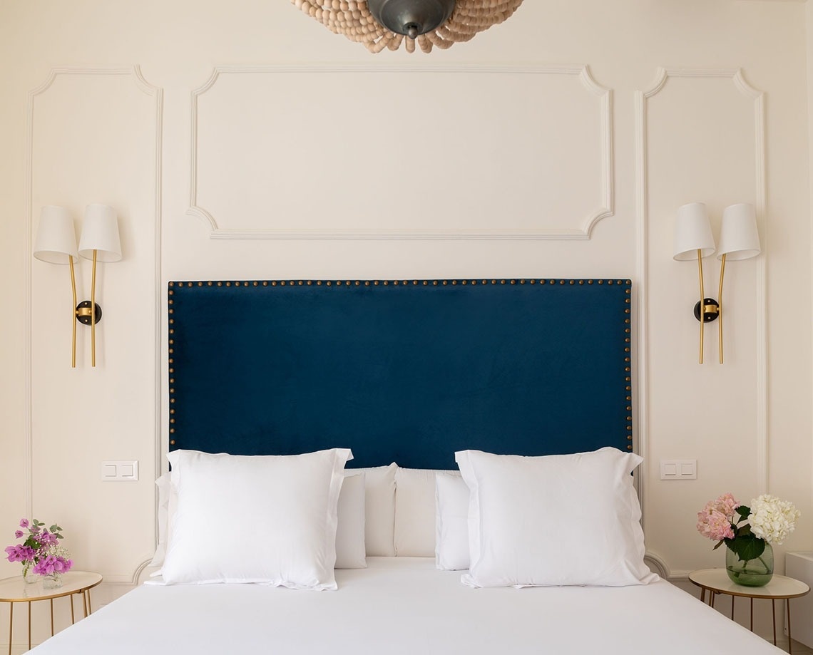 a bed with a blue headboard and white pillows