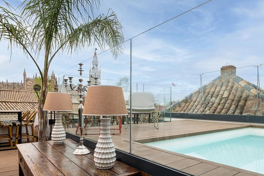 dos lámparas están sobre una mesa de madera junto a una piscina