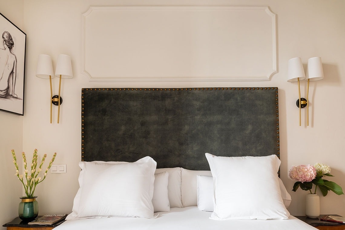 a bed with a black headboard and white pillows