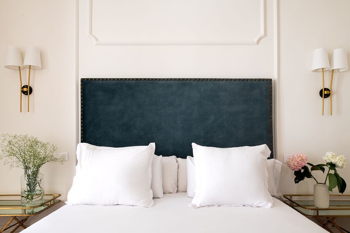 a bed with a blue headboard and white pillows