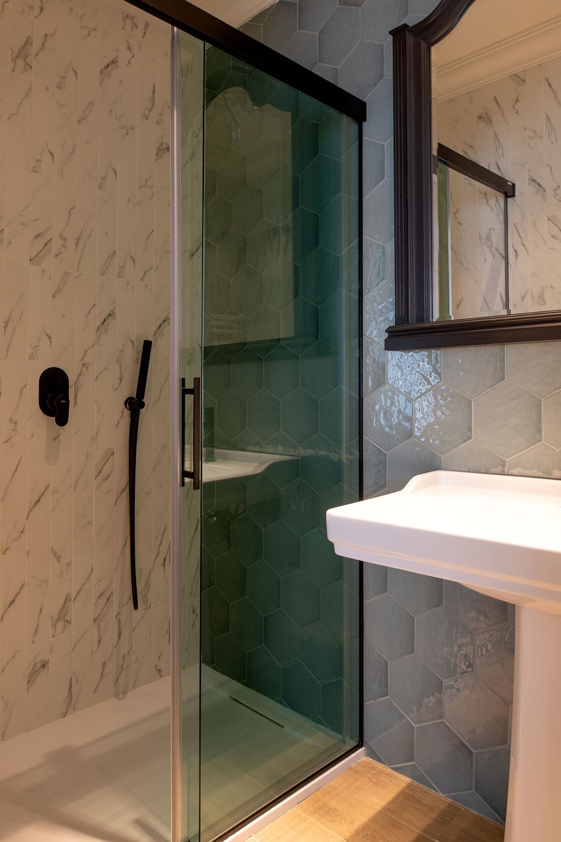 a bathroom with a sliding glass shower door and a sink