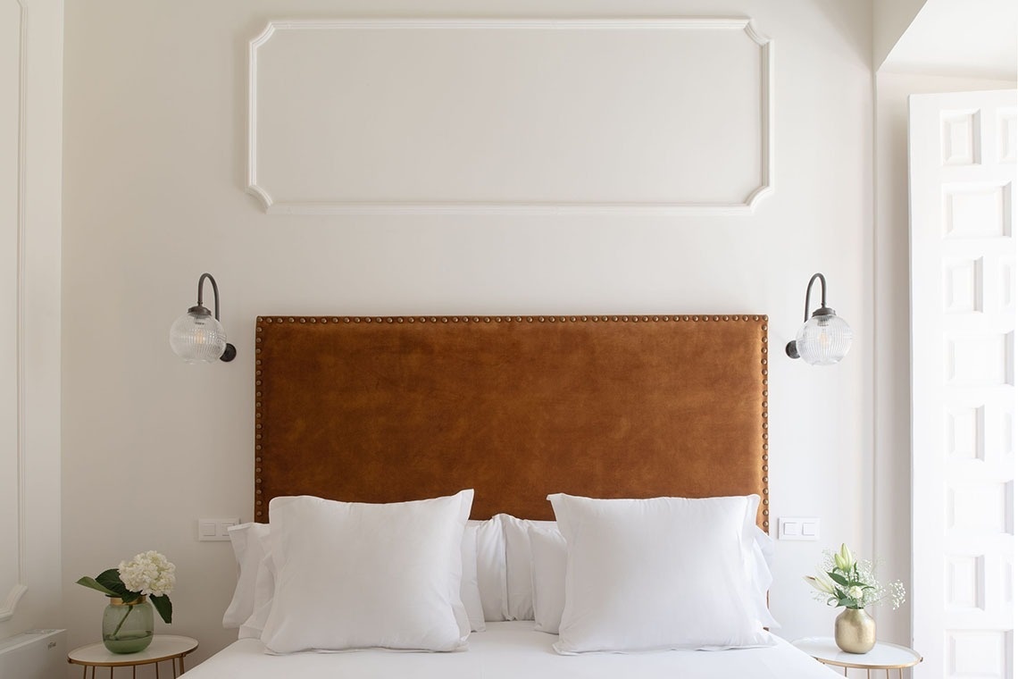 a bed with a brown headboard and white pillows