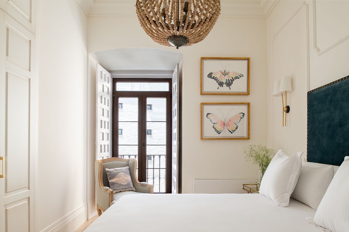 a bedroom with two framed butterflies on the wall above the bed