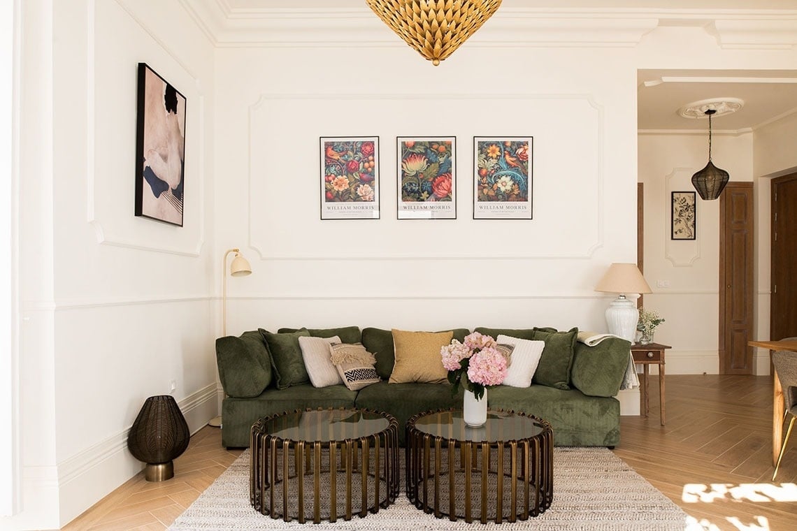 a living room with a green couch and two coffee tables