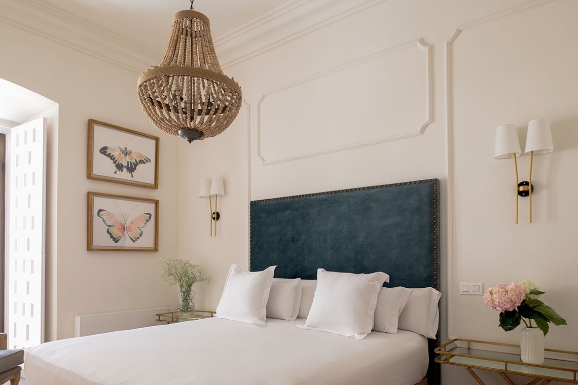 a bedroom with a bed and a chandelier hanging from the ceiling