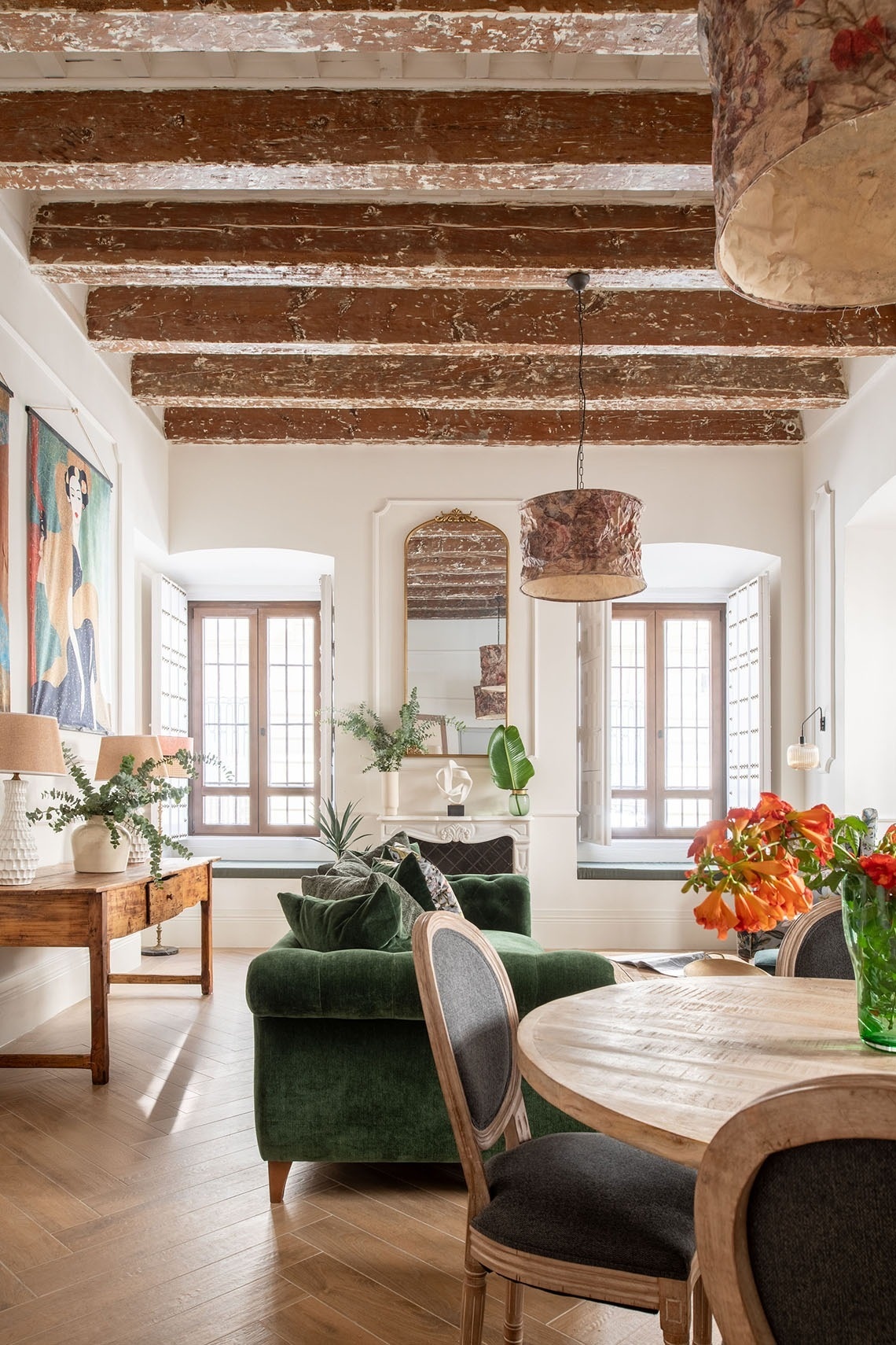 una sala de estar con un sofá verde y una mesa de comedor