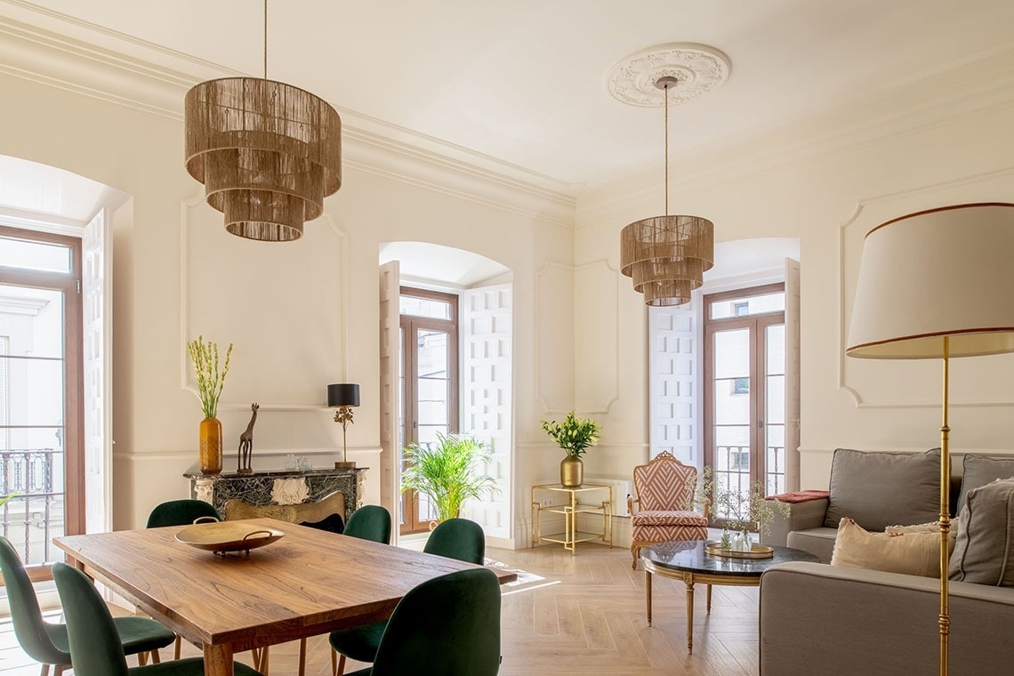 un comedor con una mesa de madera y sillas verdes