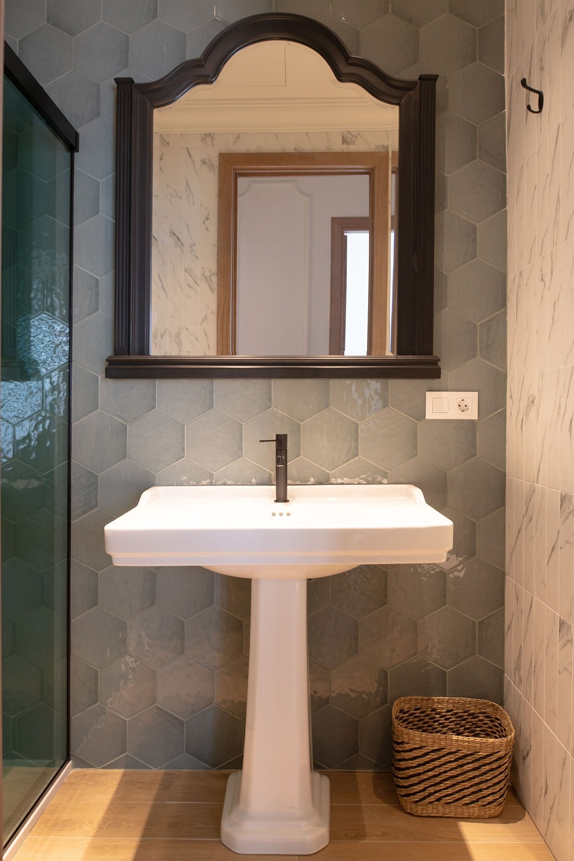 a bathroom with a pedestal sink and a mirror