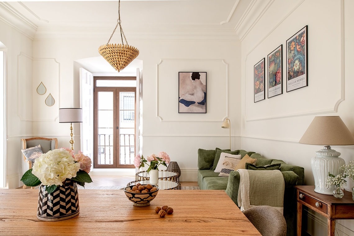 a living room with a couch and a table with a vase of flowers on it