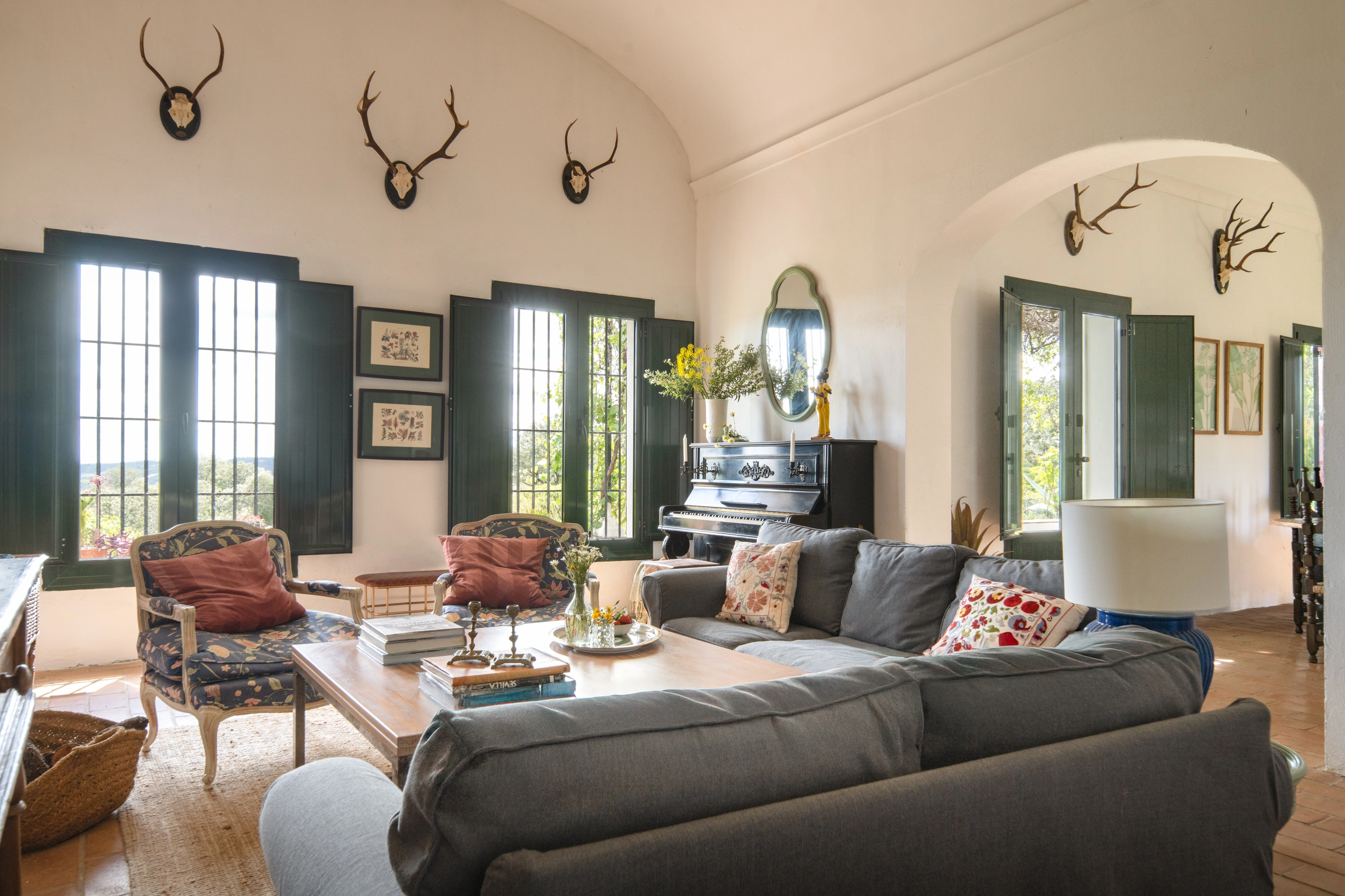 Elegant living room Epoca Suites: Corporativa with a piano, comfortable sofa, antique armchair, and large windows overlooking the countryside.