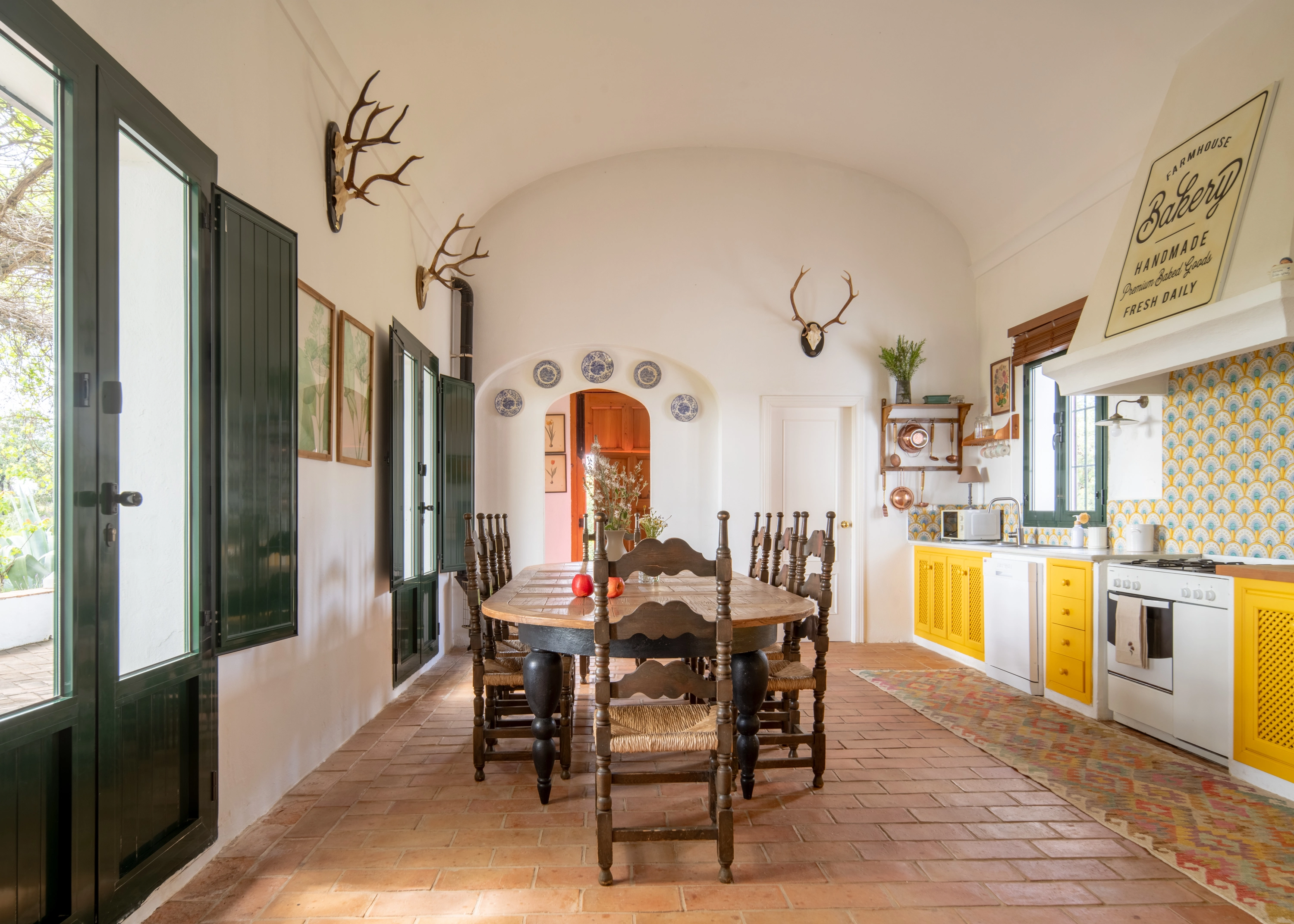 Rustic kitchen and dining room with deer antlers, French doors, and farmhouse bakery sign - ideal Epoca Suites: Corporativa.