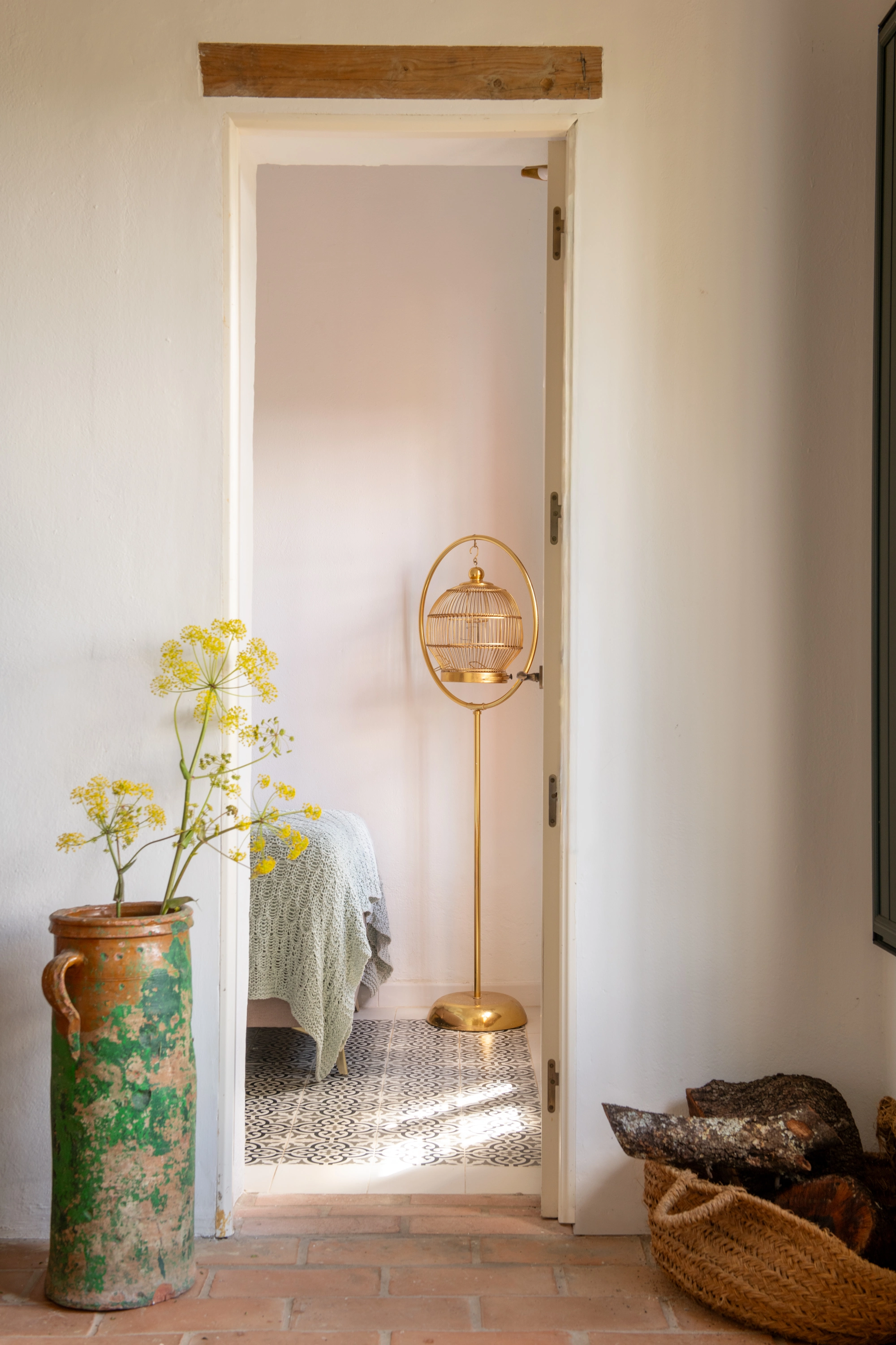 Rustic hotel entry with floral decor and a Epoca Suites: Corporativa birdcage lamp.