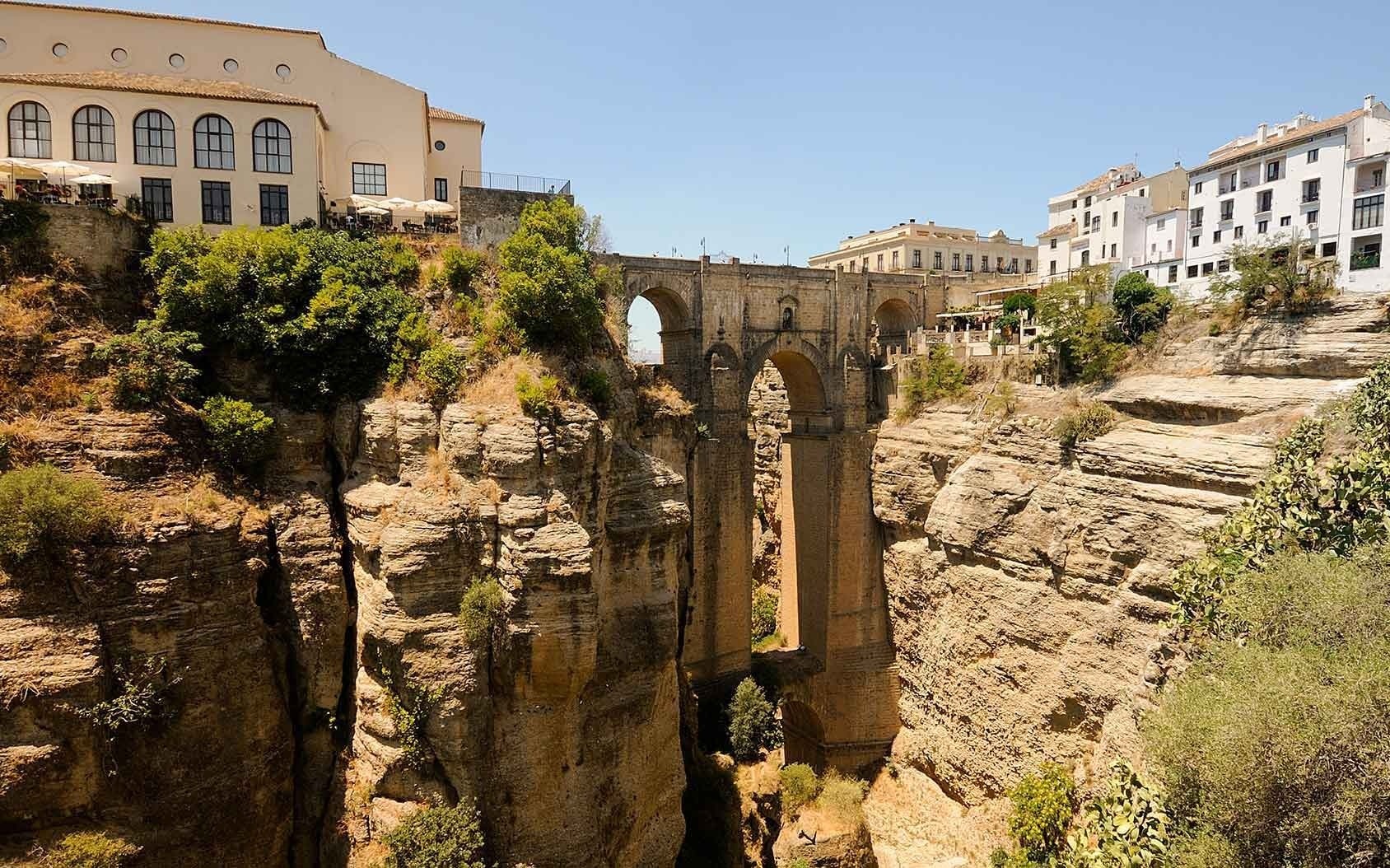 un puente sobre un cañón con un edificio al fondo