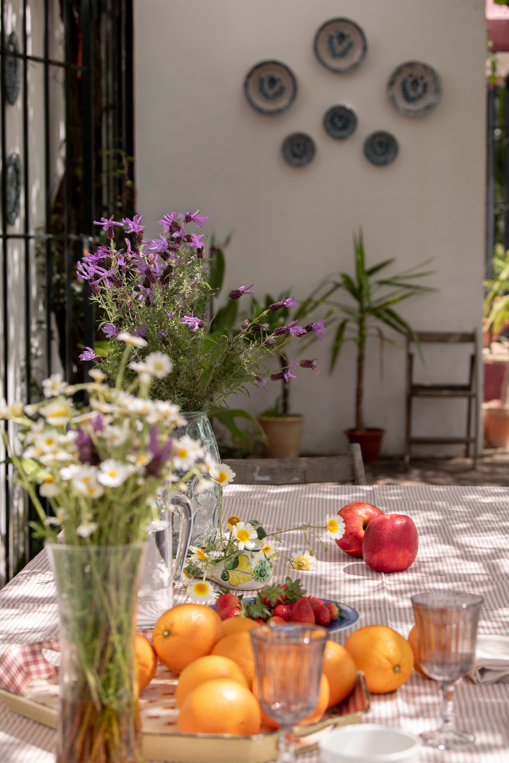 Outdoor patio table with fruit, flowers, and glasses, perfect for Epoca Suites: Corporativa dining.