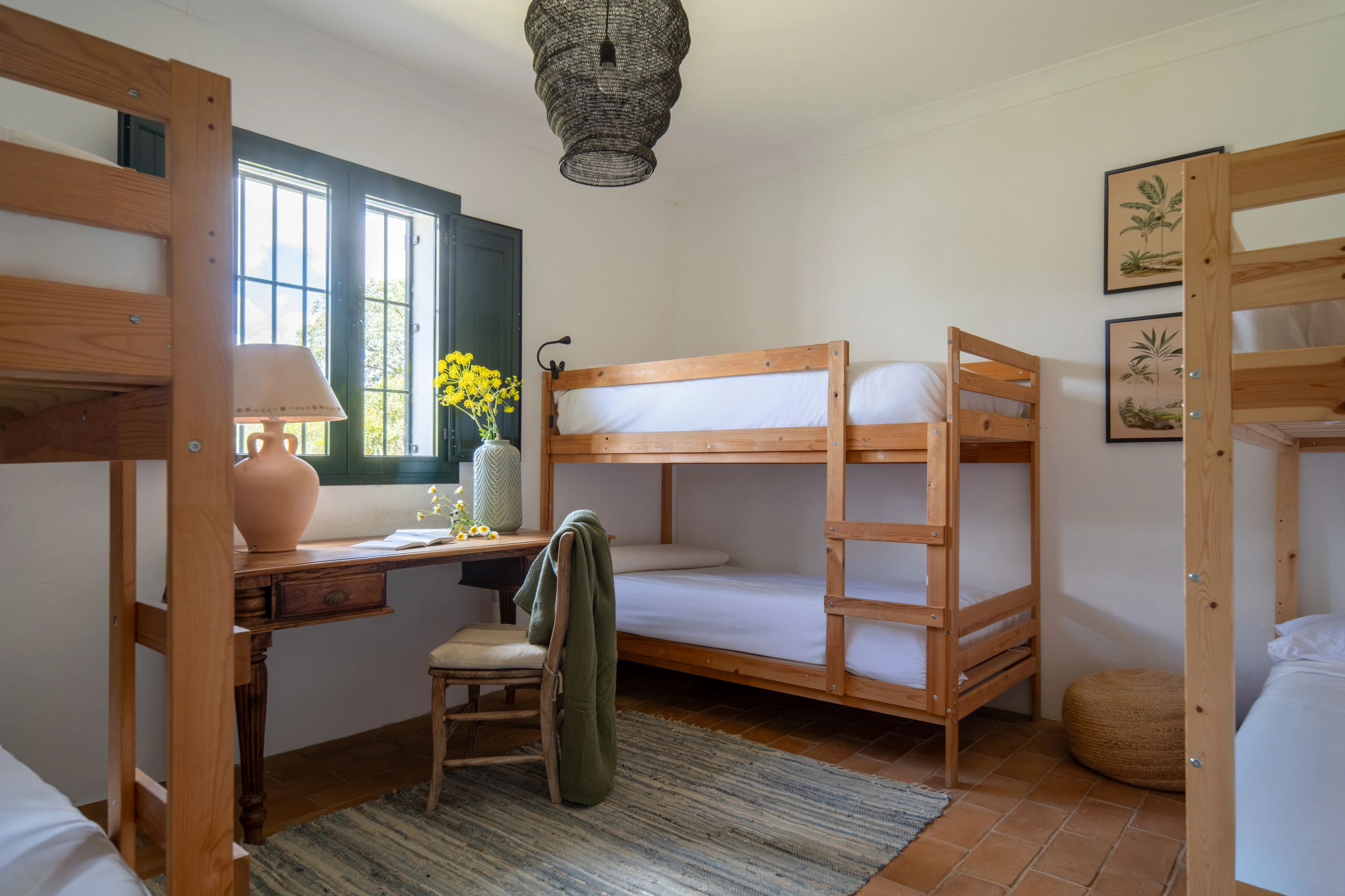 Bunk beds and desk in a bright hotel room with natural light, perfect for families seekingEpoca Suites: Corporativa.