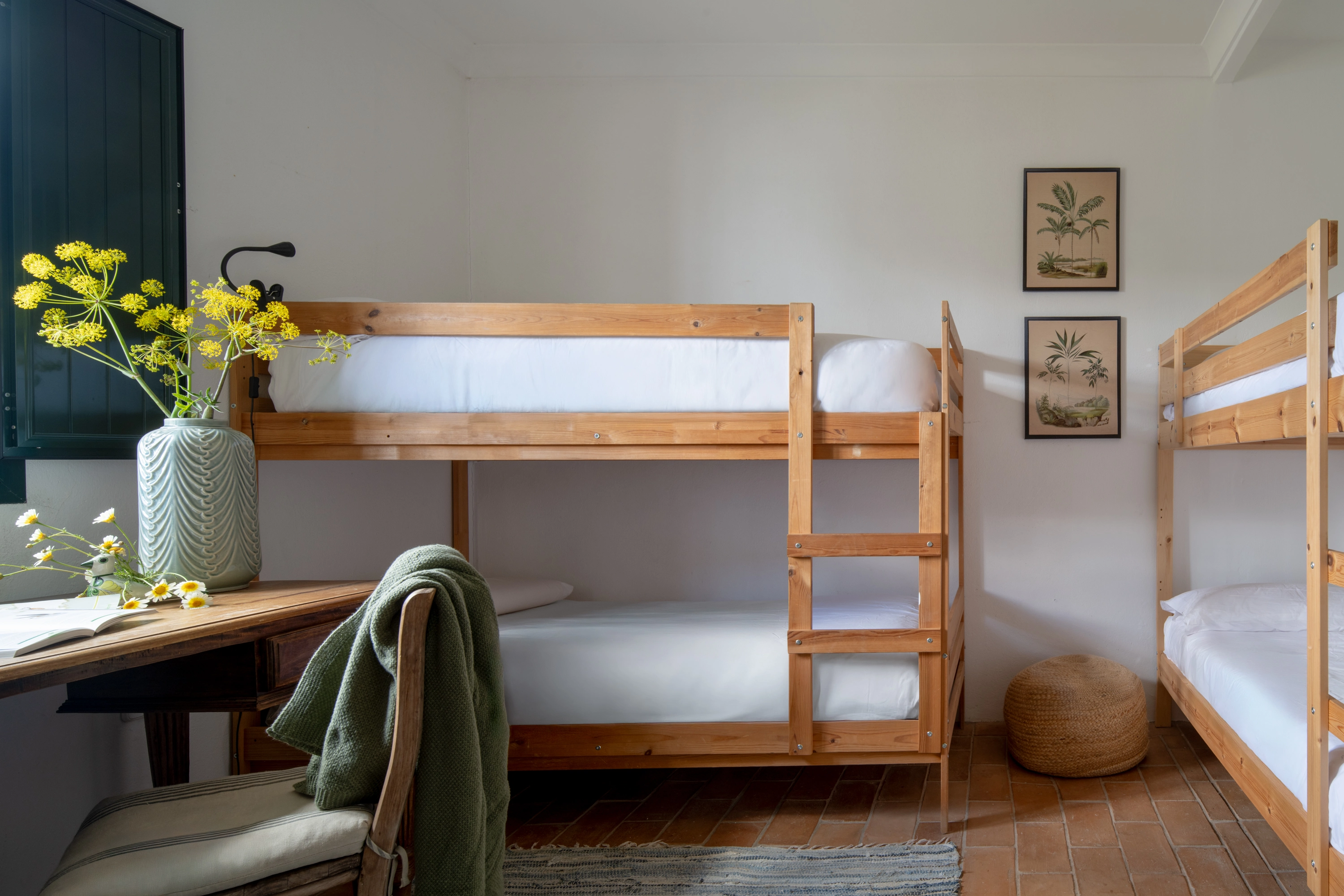 Bunk beds in a bright hotel room with floral decor and a desk, ideal for family stays Epoca Suites: Corporativa.
