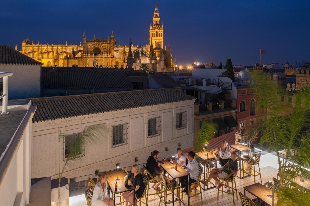 a group of people sitting at tables with a cathedral in the background