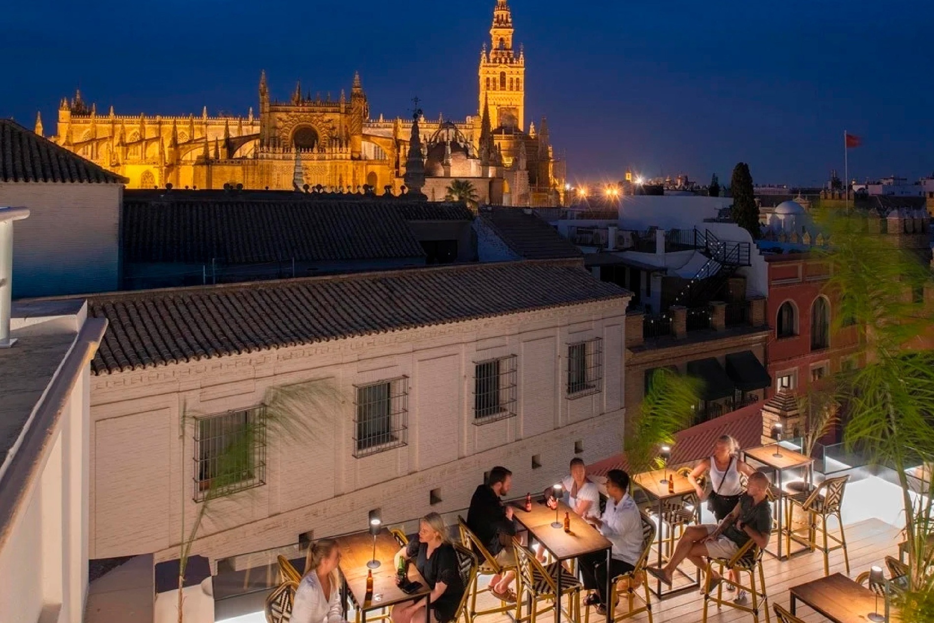 a group of people sit at tables in front of a cathedral