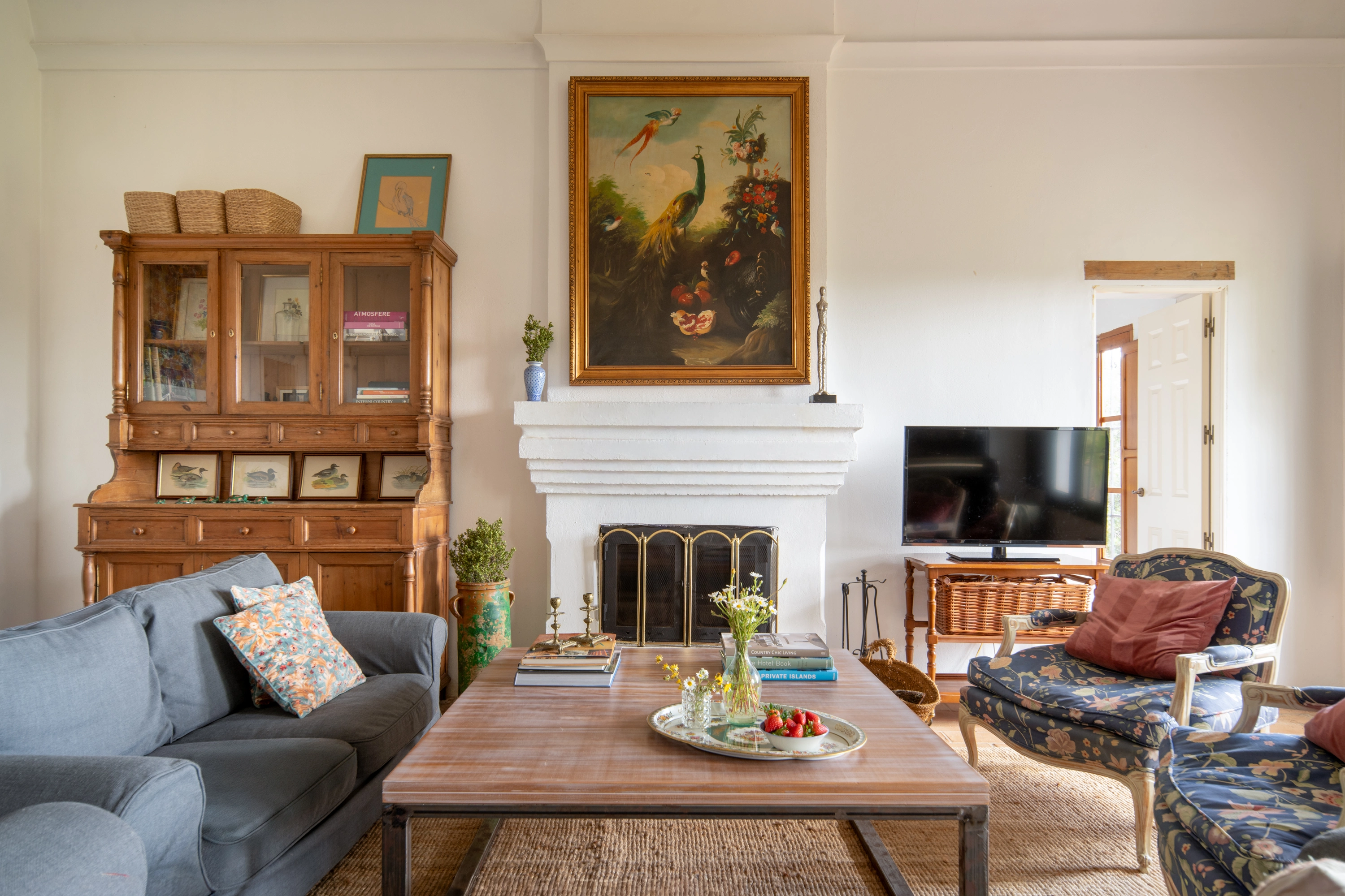 Cozy living room with vintage furniture, fireplace, and painting, perfect for a relaxing Epoca Suites: Corporativa stay.