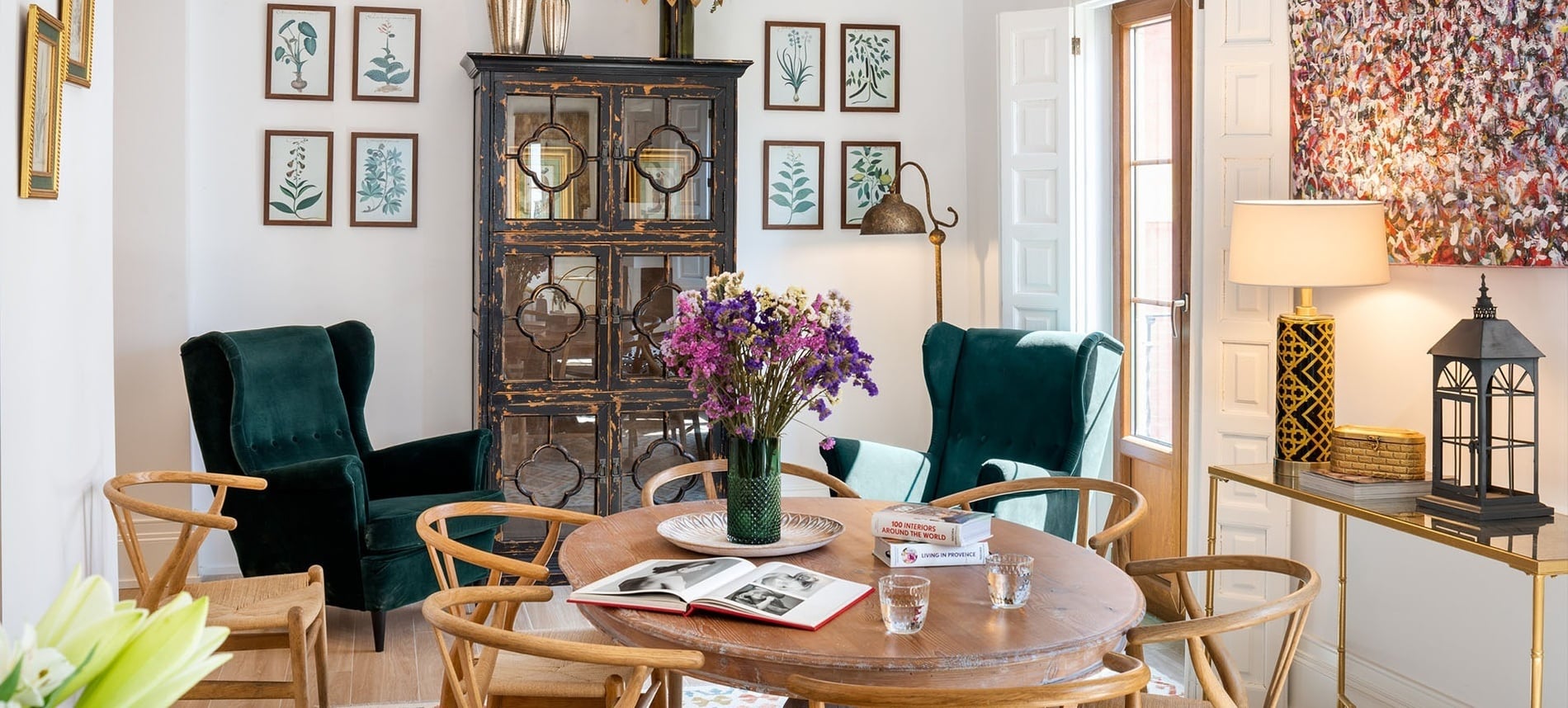 Vista panorámica de Sevilla al atardecer, con la Torre del Oro a la derecha junto al río Guadalquivir y un moderno rascacielos a lo lejos, bajo un cielo de tonos anaranjados.