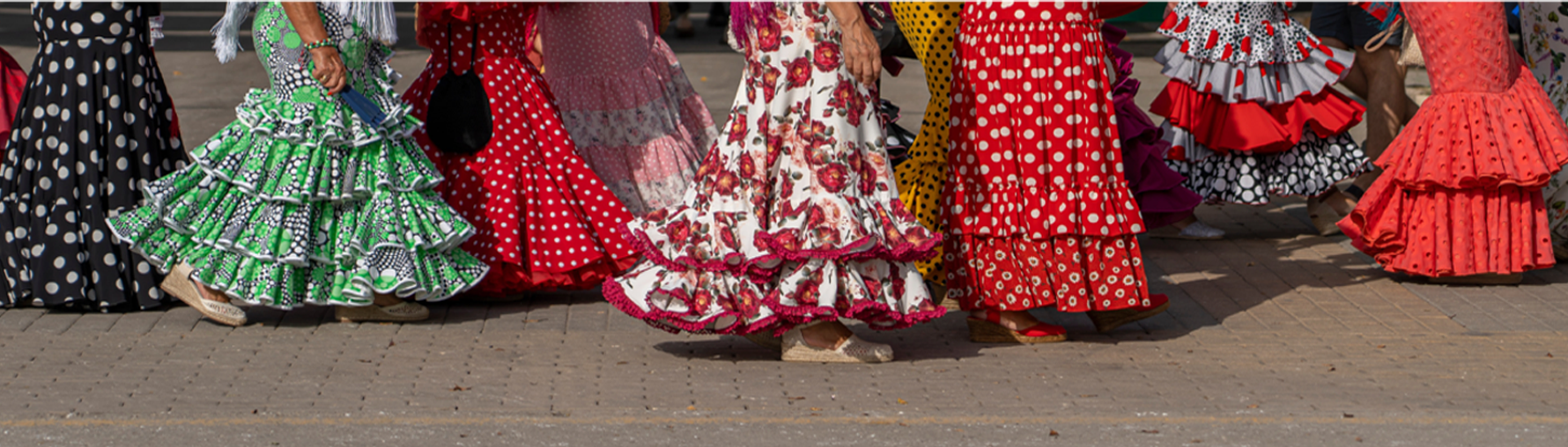 a group of women in polka dot dresses are walking down a sidewalk