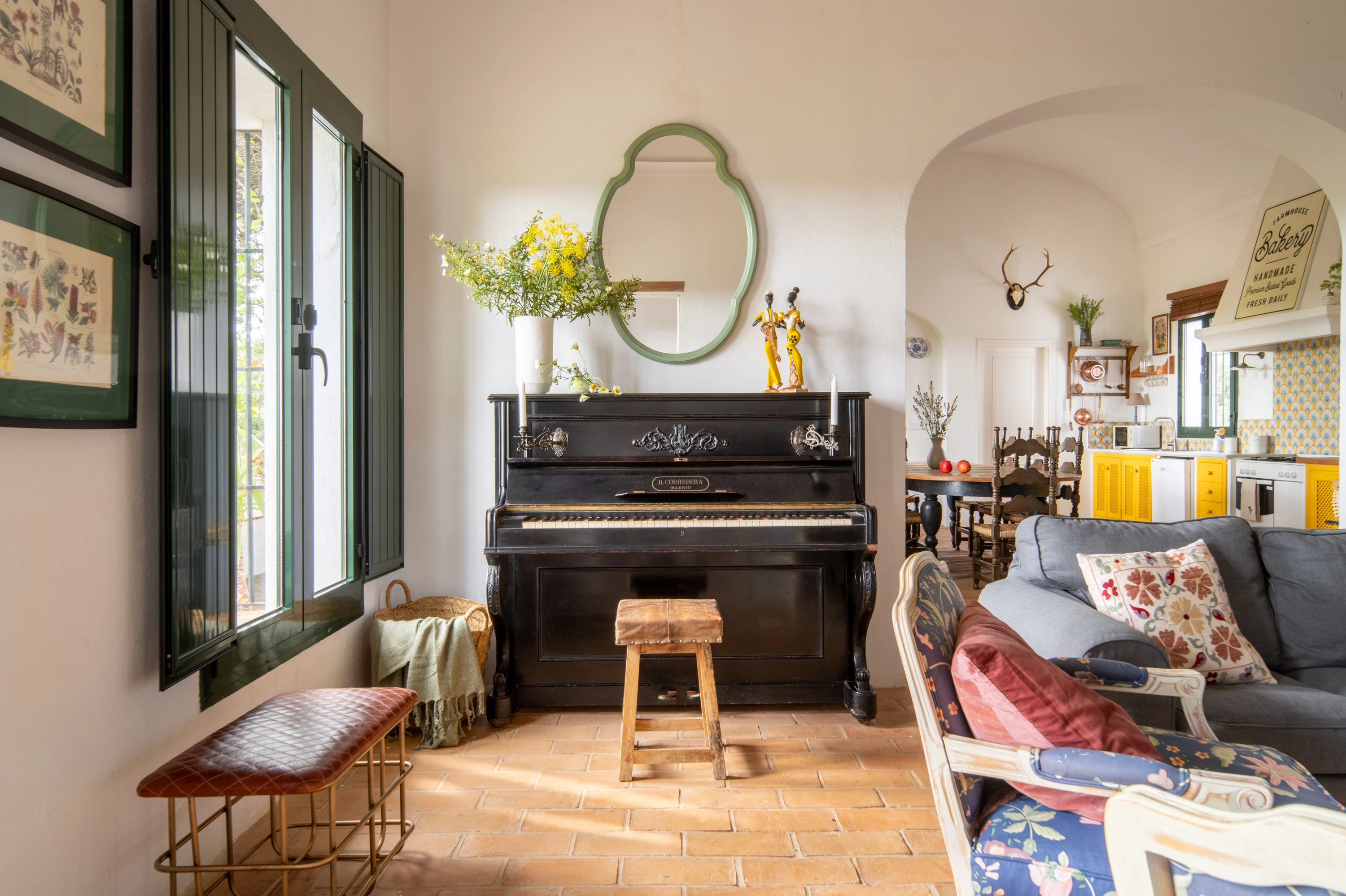 Elegant living room with piano, seating, and kitchen views, perfect for Epoca Suites: Corporativa stays.