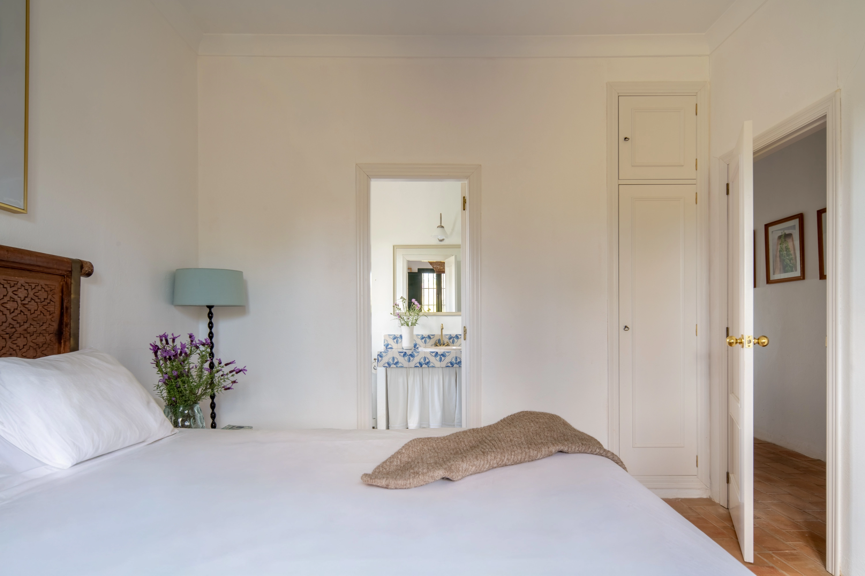 Bedroom with white linens, decorative headboard, and adjoining bathroom Epoca Suites: Corporativa.