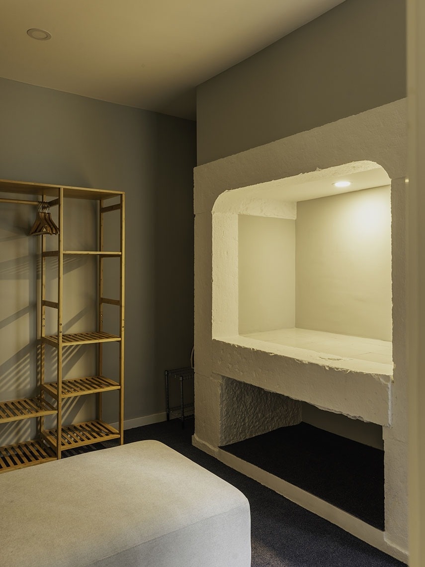 Modern room at Esqina Apartments featuring shelving and a recessed niche.