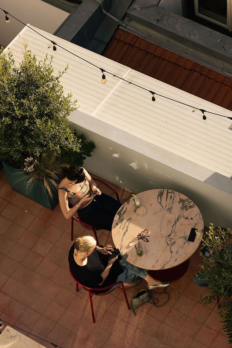 duas mulheres estão sentadas em frente a uma mesa redonda