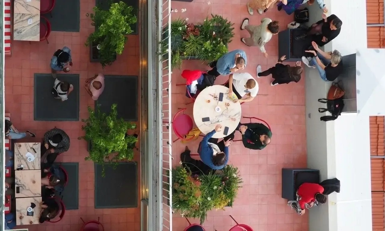 an aerial view of people sitting at tables in a restaurant