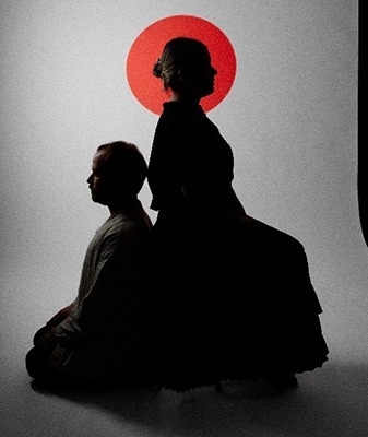 una gran multitud de personas está parada frente a un escenario en un festival de música .