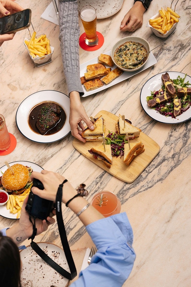 uma pessoa está tirando uma foto de uma mesa cheia de comida