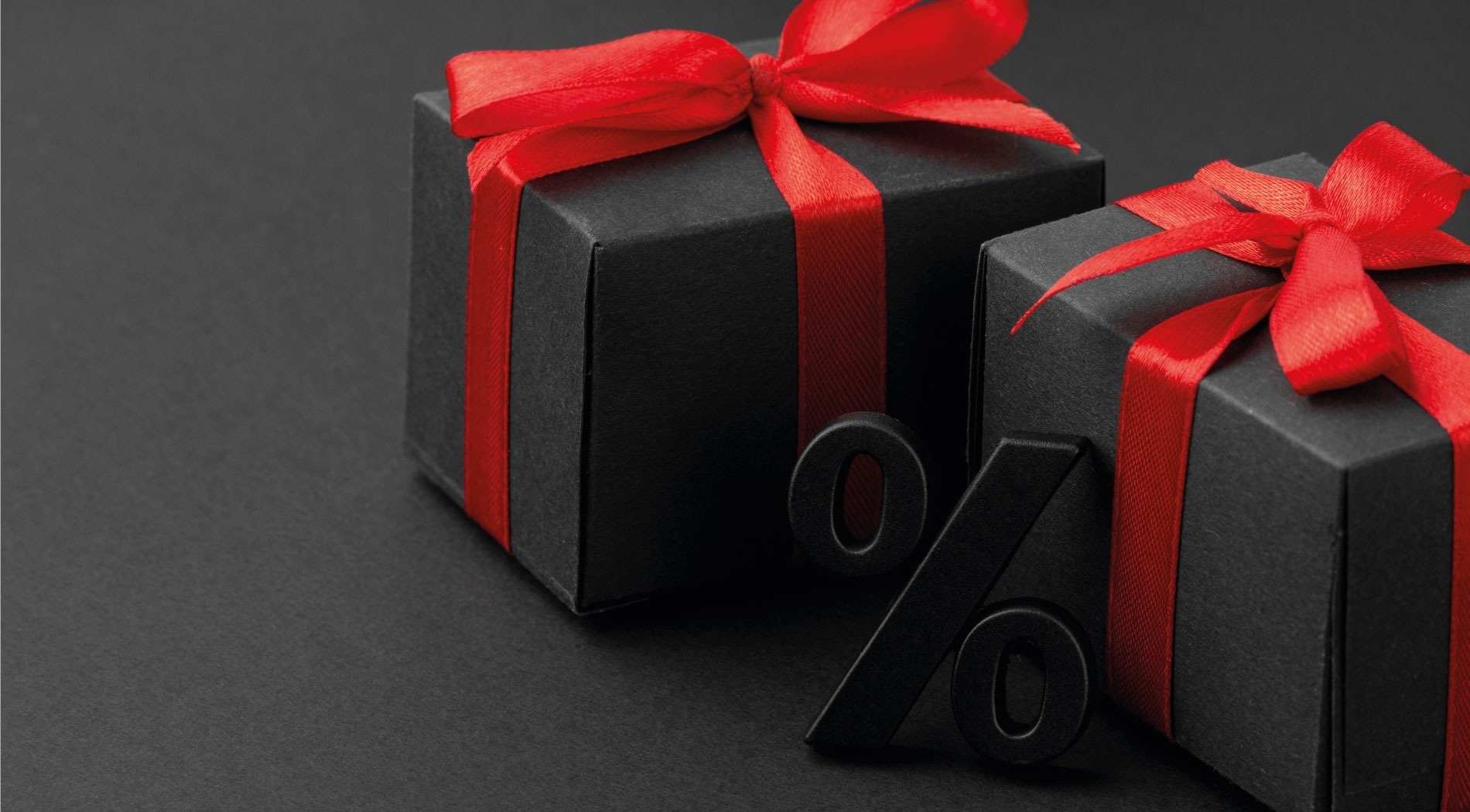 two black gift boxes with red ribbons and a black percent sign