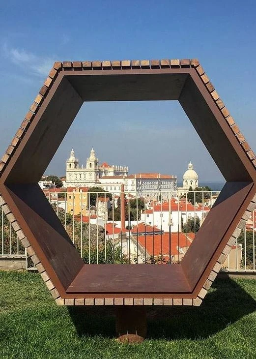 un grupo de personas están sentadas en mesas bajo una carpa decorada con guirnaldas de colores .