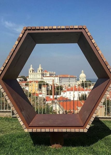 a group of people are sitting at tables under a colorful tent .