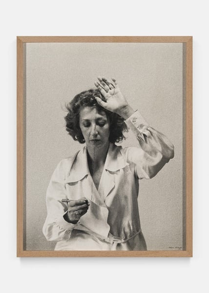 a man and a woman are sitting on the floor looking at pictures .