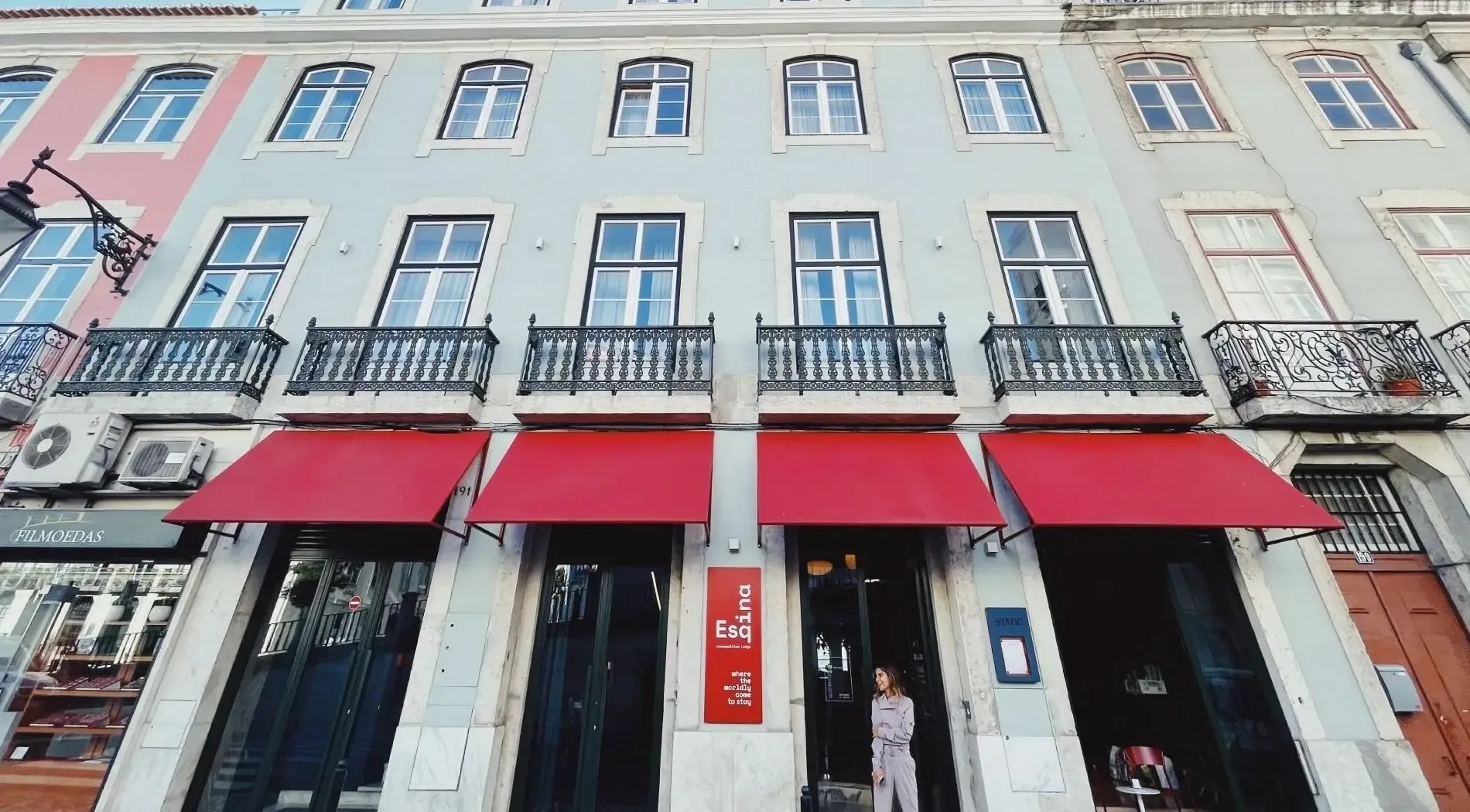 a woman stands in front of a building with a red awning that says duff