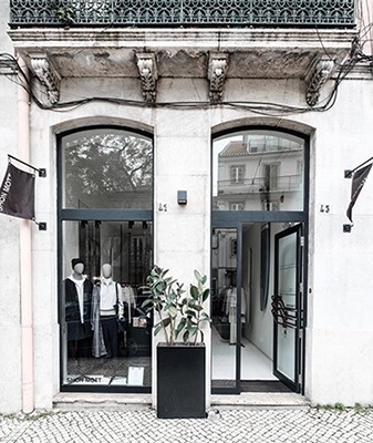 un grupo de personas están sentadas en mesas bajo una carpa decorada con guirnaldas de colores .