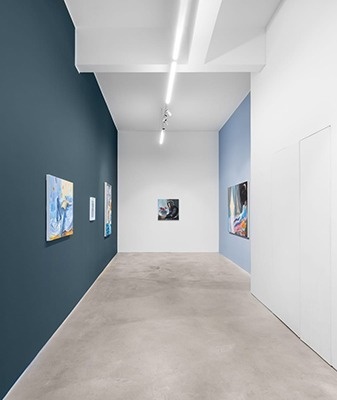 un hombre con una máscara camina frente a las letras verdes de la palabra siza