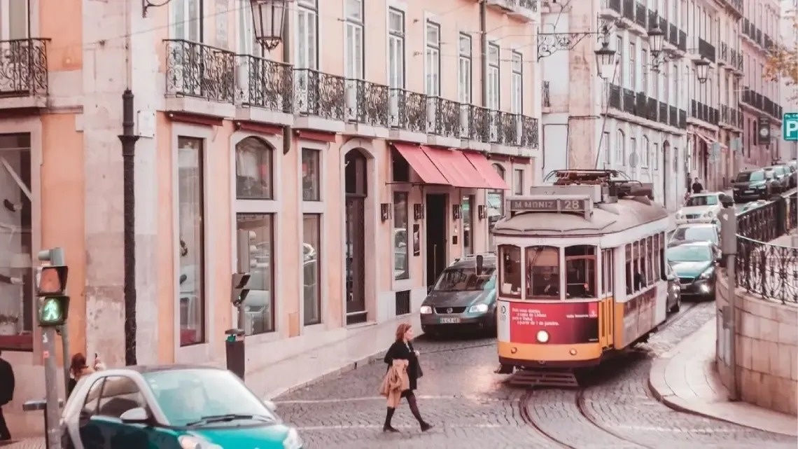 un tranvía rojo y amarillo conduce por una calle de la ciudad