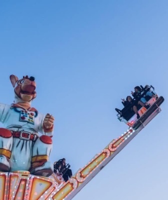 a group of people are riding a carnival ride with a cartoon character on it
