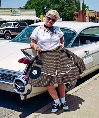 a man in a black coat is walking in front of the word siz a