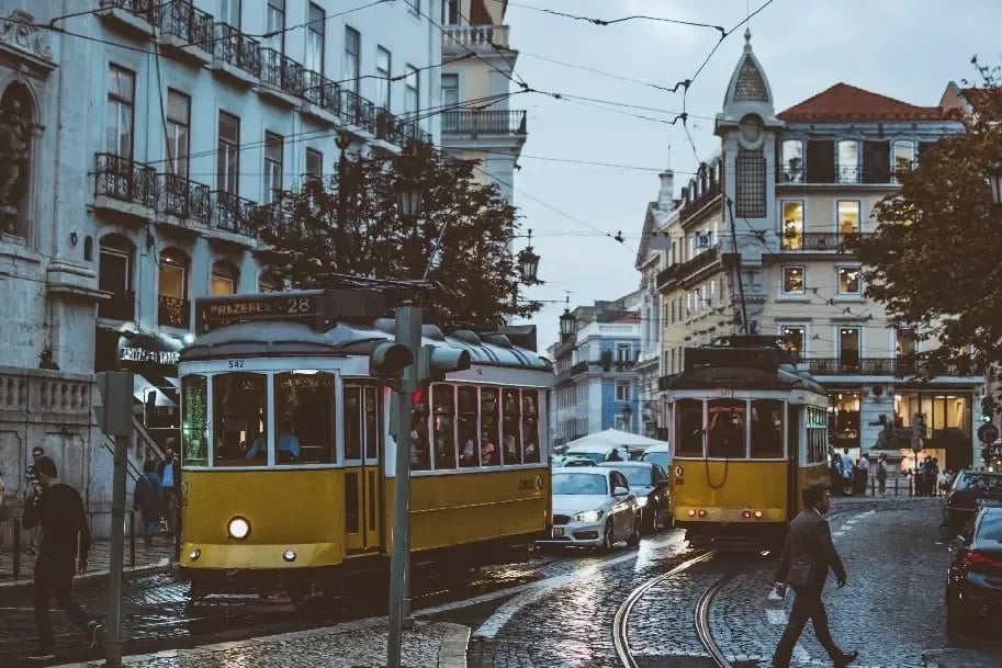 un tranvía amarillo conduce por una calle de la ciudad